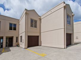 An exterior view of a building with garage doors at Tairua Holiday Home in Tairua