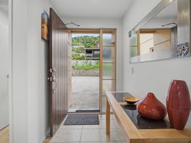 An entrance with a table and vases at Waterfront Bliss - Tairua Holiday Home Tairua