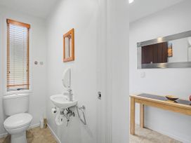 A bathroom with a toilet and a sink at Waterfront Bliss - Tairua Holiday Home Tairua