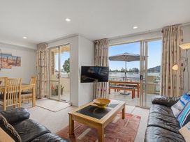 A living room with a dining table and a sofa at Waterfront Bliss - Tairua Holiday Home Tairua