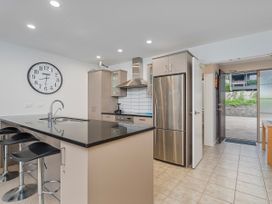 A kitchen with a stove and fridge at Waterfront Bliss - Tairua Holiday Home Tairua