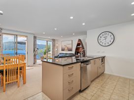 A kitchen with a dining area and outdoor view at Waterfront Bliss - Tairua Holiday Home Tairua