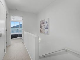 A hallway with a window and artwork at Waterfront Bliss - Tairua Holiday Home Tairua