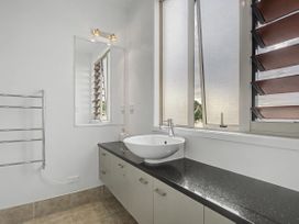 A bathroom with a sink and mirror at Waterfront Bliss - Tairua Holiday Home in Tairua