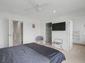 A bedroom with a bed and television at Waterfront Bliss - Tairua Holiday Home Tairua