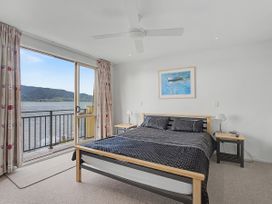 A bedroom with a bed and a window overlooking the water at Waterfront Bliss - Tairua Holiday Home Tairua