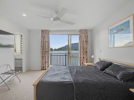 A bedroom with a bed and a television at Waterfront Bliss - Tairua Holiday Home Tairua