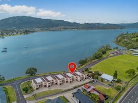 A view of waterfront buildings and the sea at Waterfront Bliss - Tairua Holiday Home, Tairua