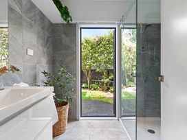 A bathroom with a wash basin and shower at The Bridge Bird Sanctuary - Auckland