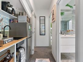 A kitchen area with a refrigerator and microwave at The Bridge Bird Sanctuary - Auckland