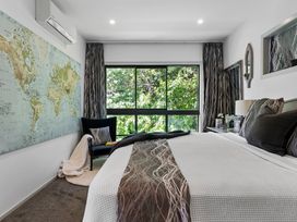 A bedroom with a world map on the wall at The Bridge Bird Sanctuary - Auckland
