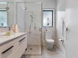 A bathroom with a shower, toilet and sink at The Bridge Bird Sanctuary - Auckland