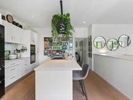 A kitchen with an island and photo wall at The Bridge Bird Sanctuary - Auckland Holiday Home Auckland
