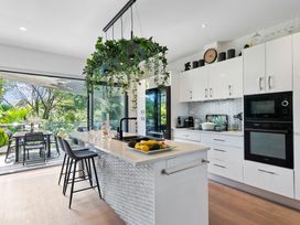 A kitchen with modern appliances and a dining area at The Bridge Bird Sanctuary - Auckland