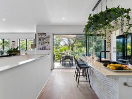 A kitchen with a countertop and bar stools at The Bridge Bird Sanctuary - Auckland Holiday Home