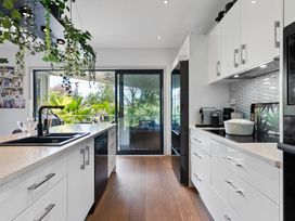 A kitchen with modern appliances and a view at The Bridge Bird Sanctuary - Auckland