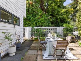 A garden with a table and chairs at The Bridge Bird Sanctuary - Auckland
