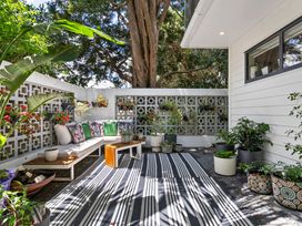 A garden area with a seating arrangement and plants at The Bridge Bird Sanctuary - Auckland