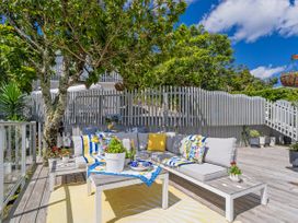 An outdoor seating area with a sofa and table at Panoramic Views on Paku - Tairua