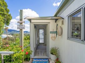 An entrance with a welcome sign and fishing sign at Panoramic Views on Paku - Tairua Family Retreat, Tairua