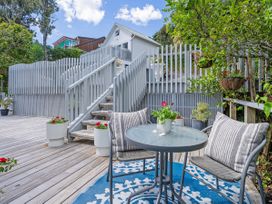 An outdoor seating area with a table and chairs at Panoramic Views on Paku - Tairua