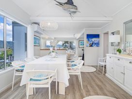 A dining room with a table and chairs at Panoramic Views on Paku - Tairua