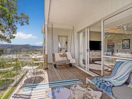 A balcony with a swing seat and view at Panoramic Views on Paku - Tairua