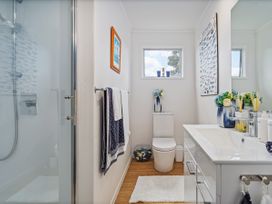 A bathroom with a shower, toilet, and sink at Panoramic Views on Paku - Tairua