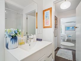 A bathroom with a vanity and mirror at Panoramic Views on Paku - Tairua Family Retreat