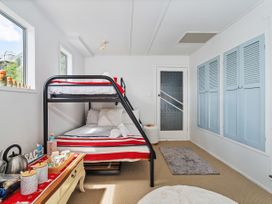 A bedroom with a bunk bed and storage cabinet at Panoramic Views on Paku - Tairua Family Retreat