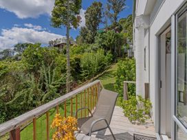 An outdoor area with a chair and plants at Panoramic Views on Paku - Tairua