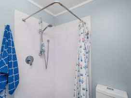 A bathroom with a shower and towel at Panoramic Views on Paku - Tairua Family Retreat Tairua