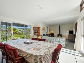 A dining area with a table and chairs at Maison Pierre Rouge - Duvauchelle Holiday Home Akaroa