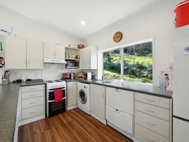 A kitchen with a sink and stove at Maison Pierre Rouge - Duvauchelle Holiday Home Akaroa