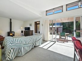 A living room with a sofa and television at Maison Pierre Rouge - Duvauchelle Holiday Home Akaroa