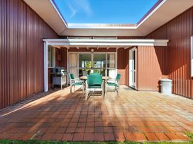 An outdoor seating area with a table and chairs at Maison Pierre Rouge - Duvauchelle Holiday Home Akaroa