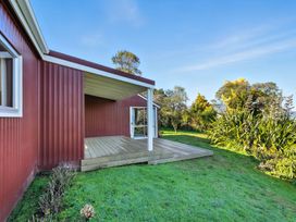 A house with a deck and garden at Maison Pierre Rouge - Duvauchelle Holiday Home Akaroa