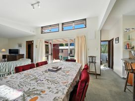 A dining room with a table and chairs at Maison Pierre Rouge - Duvauchelle Holiday Home Akaroa