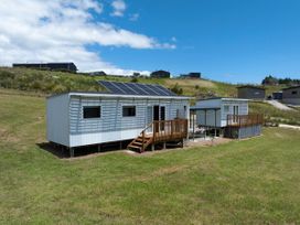 A house with solar panels and a deck at Coopers Beach