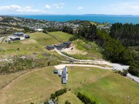 An aerial view of houses and a road near the ocean at Coopers Beach