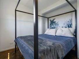A bedroom with a four-poster bed at Coopers Beach in Coopers Beach