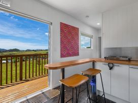 A kitchen with a bar counter and stools at Coopers Beach