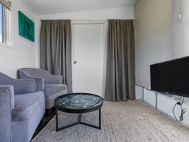 A living room with a sofa, coffee table, and television at Coopers Beach