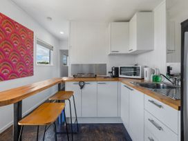 A kitchen with a bar counter and stools at Coopers Beach