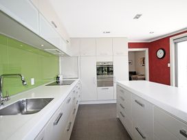 A kitchen with a sink, countertop, and stove at Relax on Richmond - Taranaki Holiday Home in New Plymouth