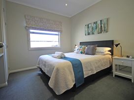 A bedroom with a bed and bedside table at Relax on Richmond - Taranaki Holiday Home, New Plymouth