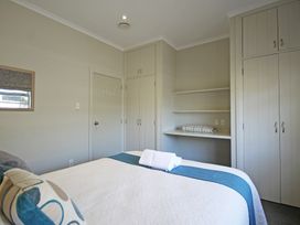 A bedroom with a bed and storage cabinets at Relax on Richmond - Taranaki Holiday Home, New Plymouth