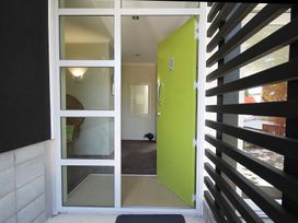 An entryway featuring a green door and a chair at Relax on Richmond - Taranaki Holiday Home in New Plymouth