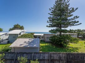 An outdoor view of houses and a tree near the ocean at Whangapoua