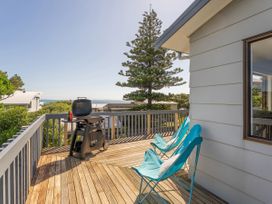 A deck with chairs and a grill at Whangapoua